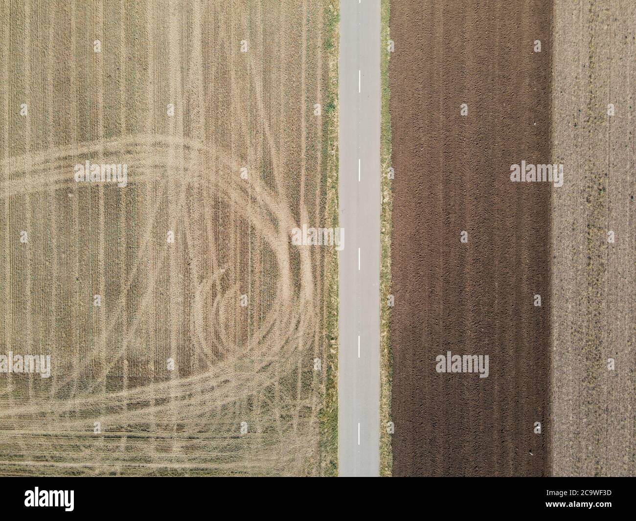 Strada di campagna tra i campi agricoli a Dobrogea, Romania. Vista aerea. Foto Stock