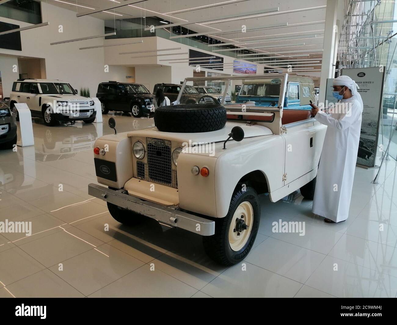 Il vecchio modello Land Rover Defender è stato presentato in uno showroom Land Rover per celebrare il lancio della nuova serie 2021 Defender 110. Foto Stock