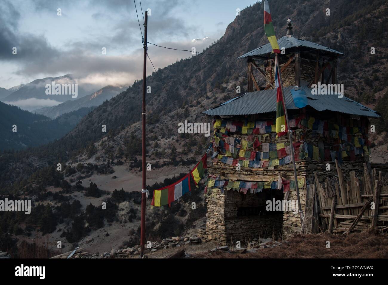 Colorate bandiere di preghiera buddista monumento in pietra, Pisang superiore, trekking circuito Annapurna, Himalaya, Nepal Foto Stock