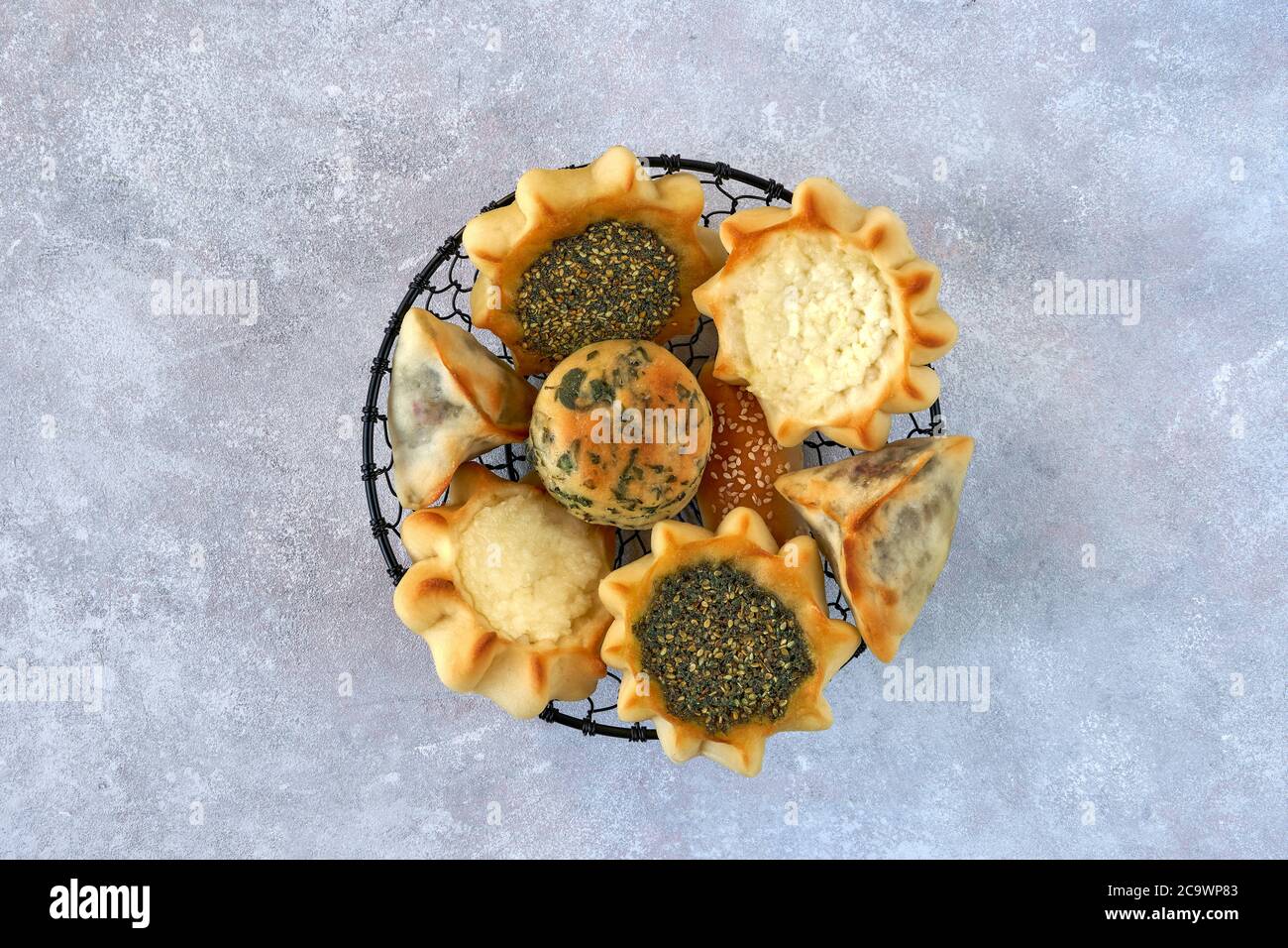 Pasticceria, fatayer o samosa, manaqeesh con zaatar e formaggio bianco su tavola di legno Foto Stock