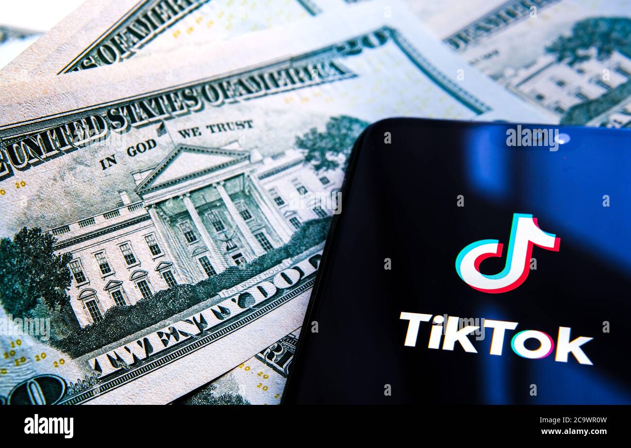 Stone / Regno Unito - 1 agosto 2020: Logo TikTok visto su uno smartphone e la Casa Bianca sulla nota da 20 dollari, fuoco selettivo. Concetto per Tikto Foto Stock