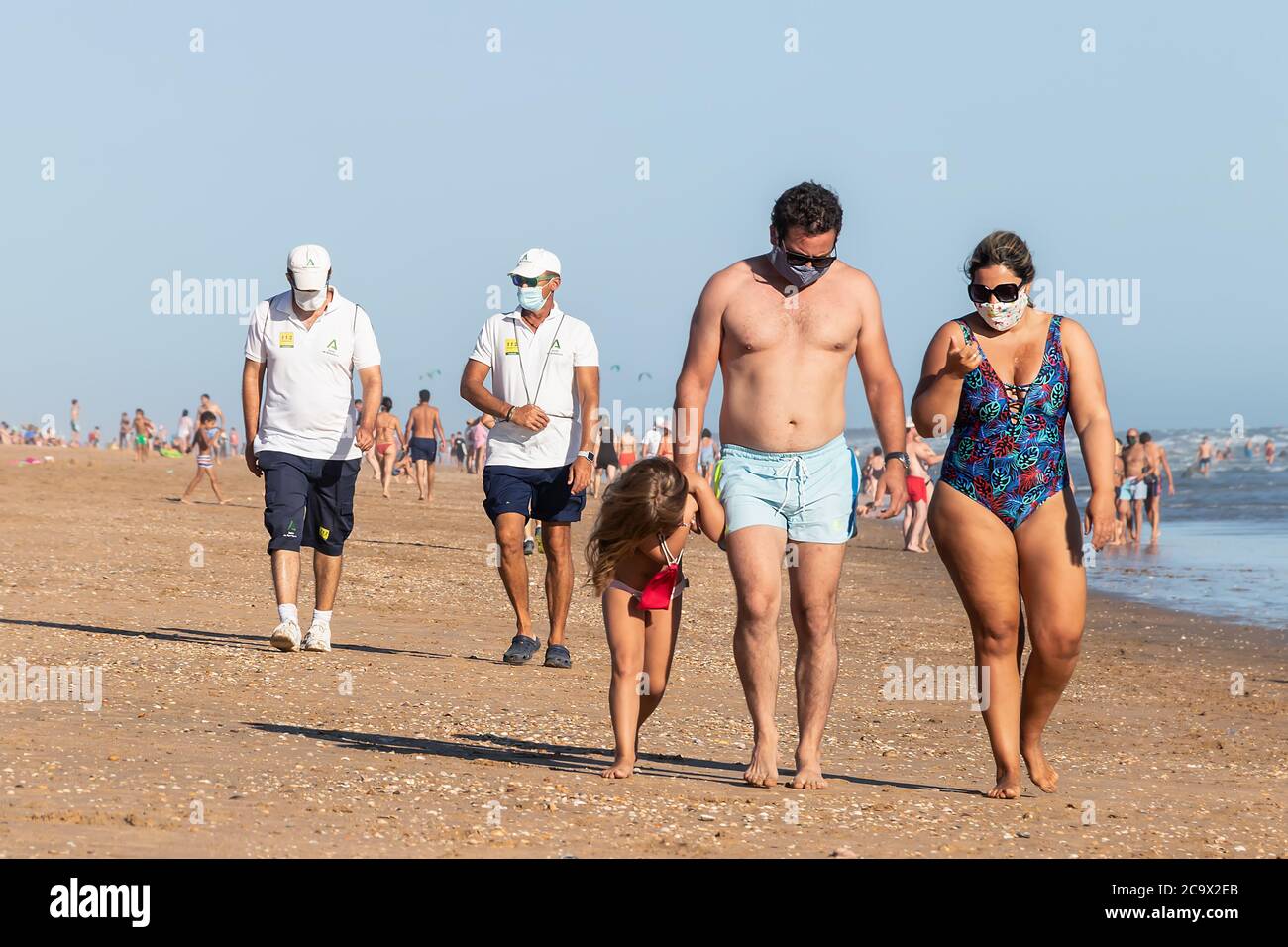 Punta Umbria, Huelva, Spagna - 2 agosto 2020: Guardia di sicurezza della spiaggia di Junta de Andalucia sta controllando l'allontanamento sociale e l'uso della maschera protettiva Foto Stock