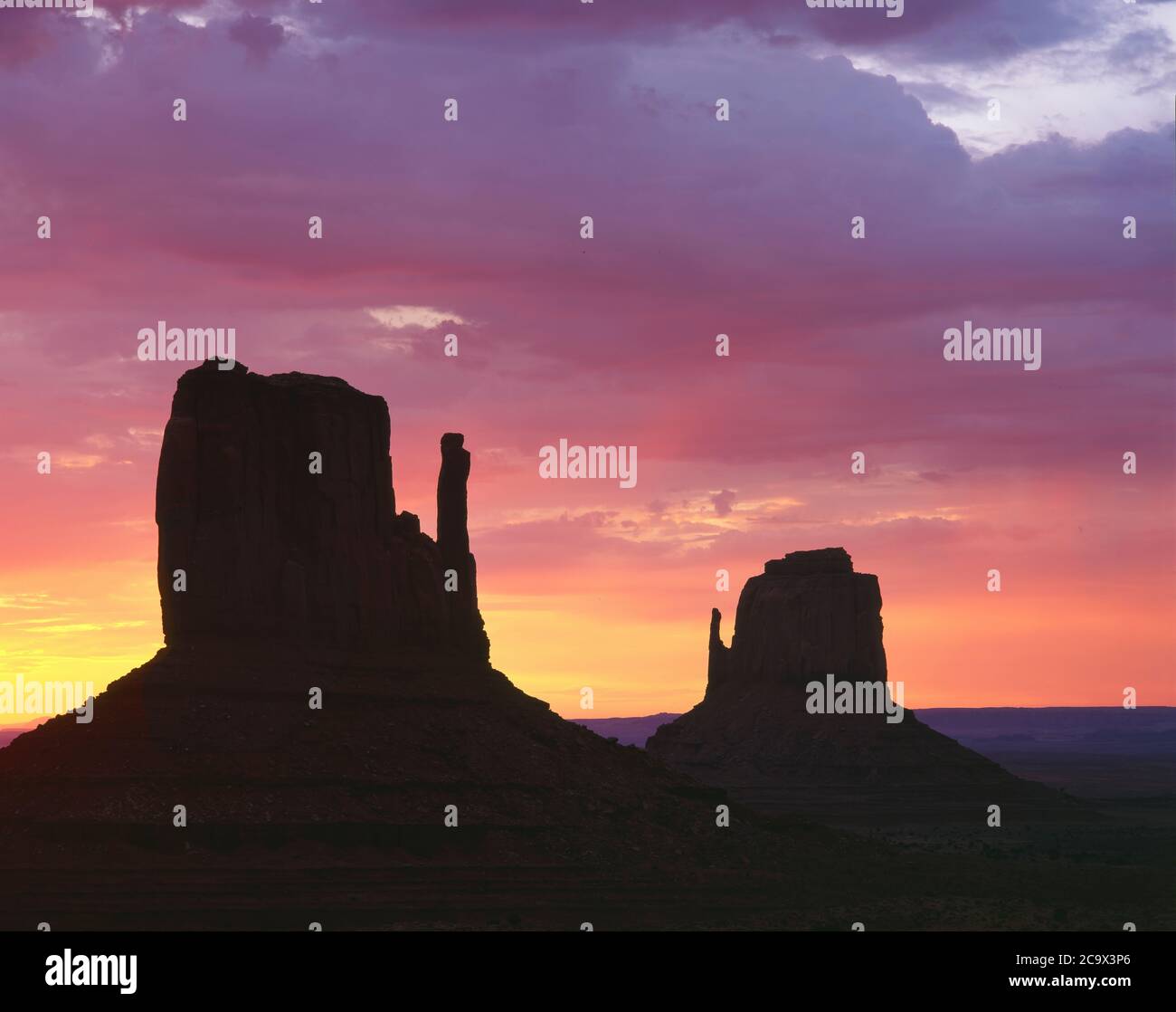 Monument Valley Navajo Tribal Park AZ / AUG cielo pastello all'alba oltre il Mitten buttes a sinistra e a destra. Foto Stock