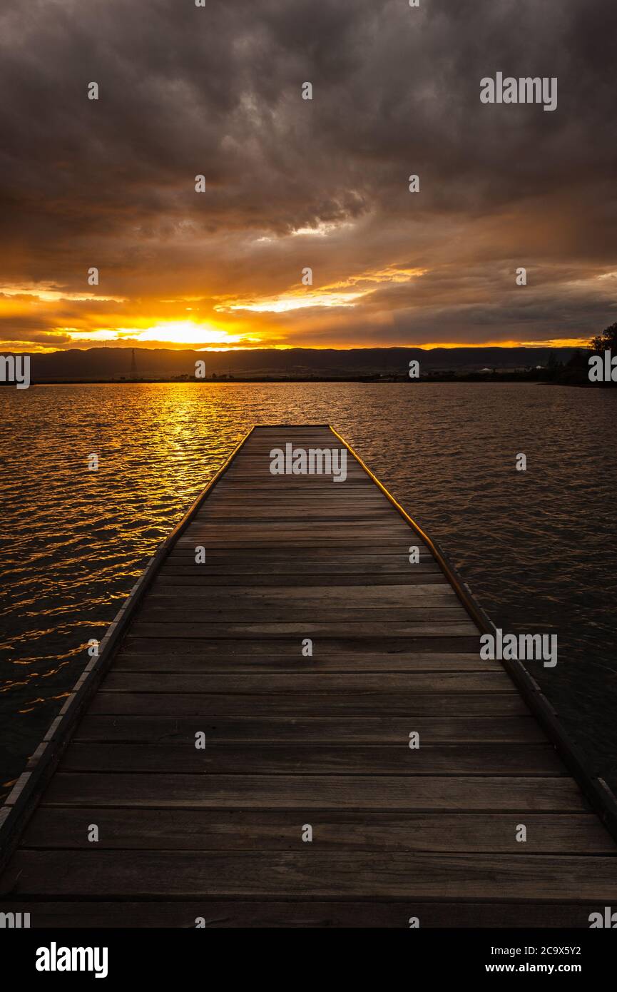 Vista del tramonto lungo un molo in legno sul lato occidentale del porto di Port Pirie, nell'Australia Meridionale. Foto Stock