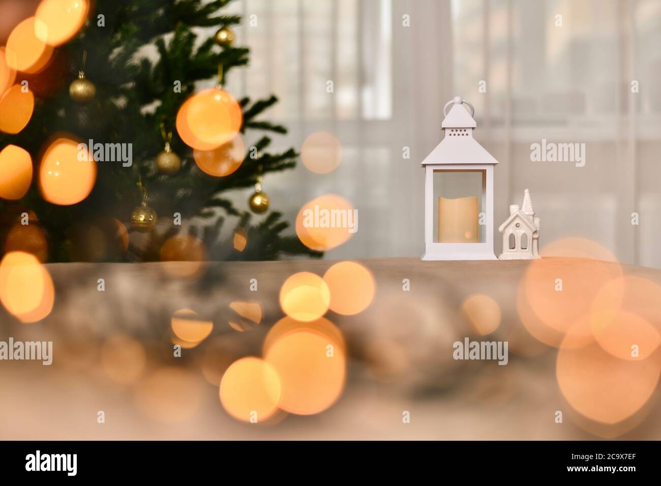 Composizione di Natale di Capodanno, albero di Natale, lanterna a candela e porcellana bianca casa in fiaba luci calde. Foto Stock