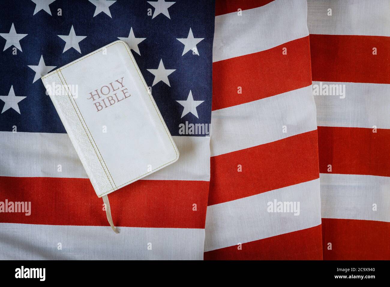 Leggere il libro della Sacra Bibbia con la preghiera per l'america sopra la bandiera americana del ruffle su tavola di legno Foto Stock