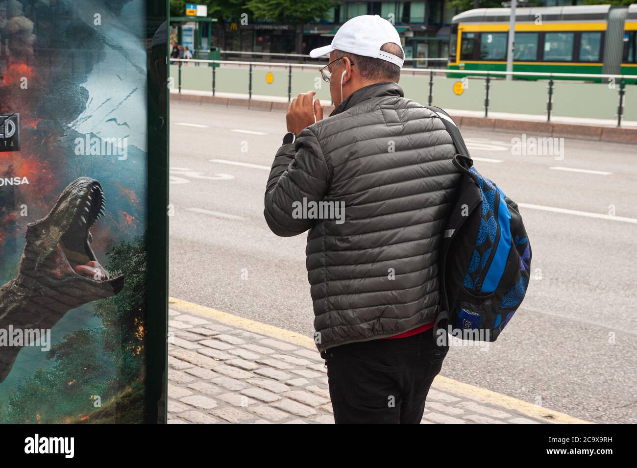 24.06.2018, Helsinki, Finlandia, Europa - UN uomo passa davanti a un tabellone pubblicitario per un film in una fermata dell'autobus nella capitale finlandese. Foto Stock