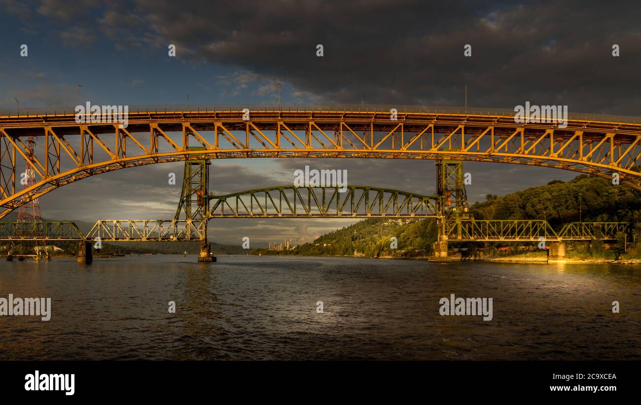 Tramonto sul secondo ponte Narrows (Ironworkers Bridge) della Trans Canada Highway e un ponte ferroviario, sopra Burrard Inlet e Vancouver Harbour Foto Stock