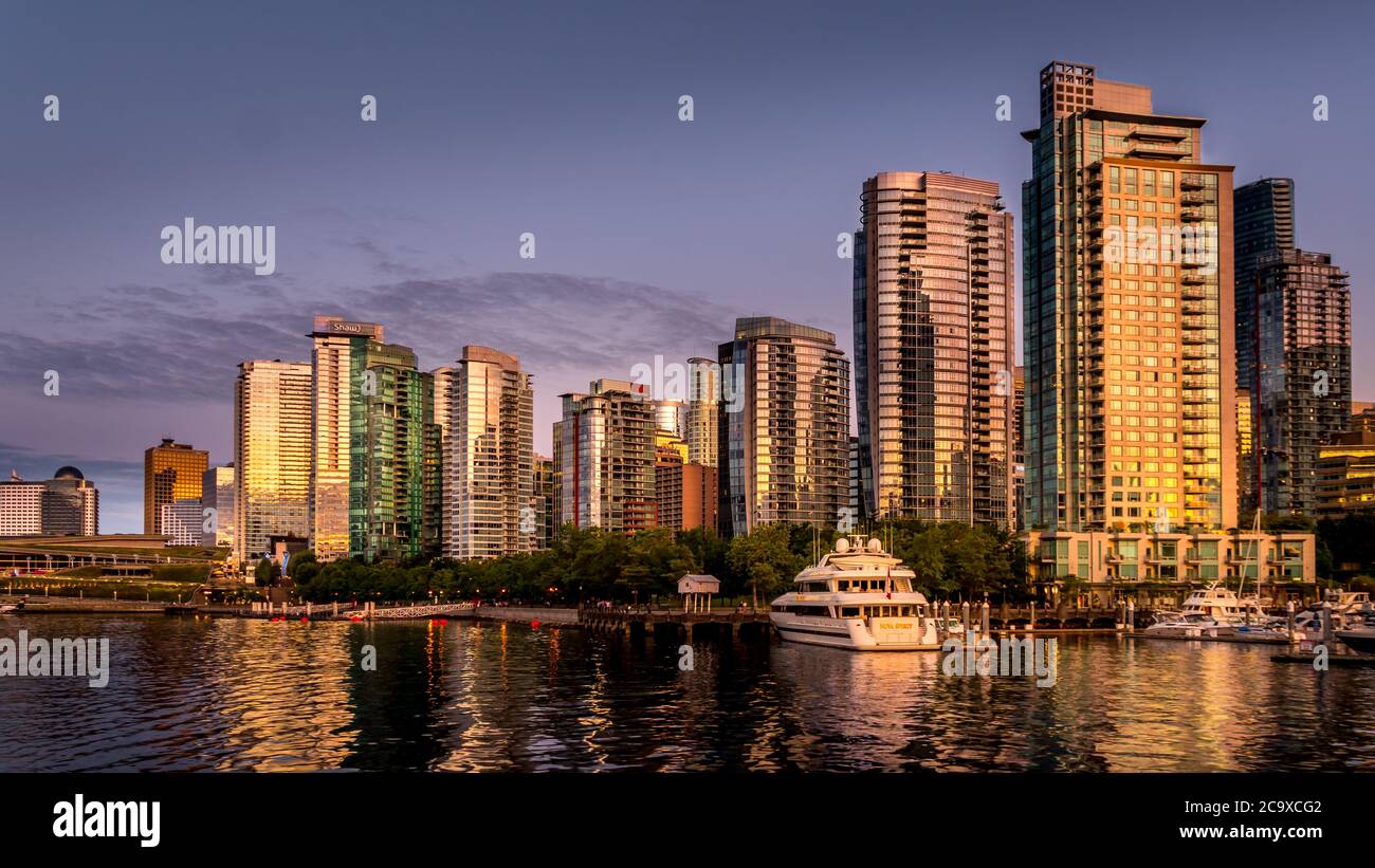 Tramonto sugli alti edifici lungo la riva del Coal Harbour nel centro di Vancouver Foto Stock