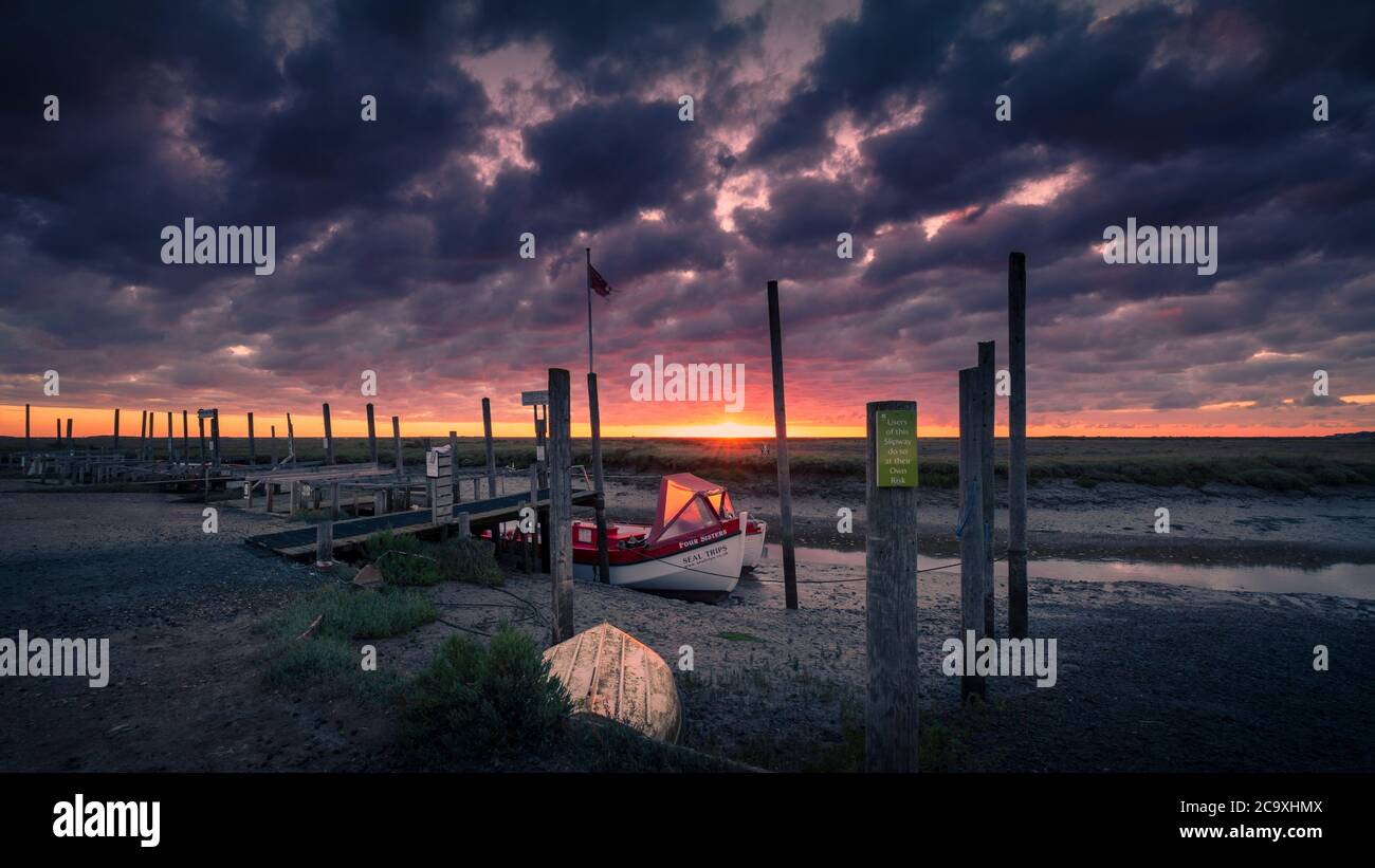 Il sole illumina una barca sulla costa del Norfolk. Foto Stock