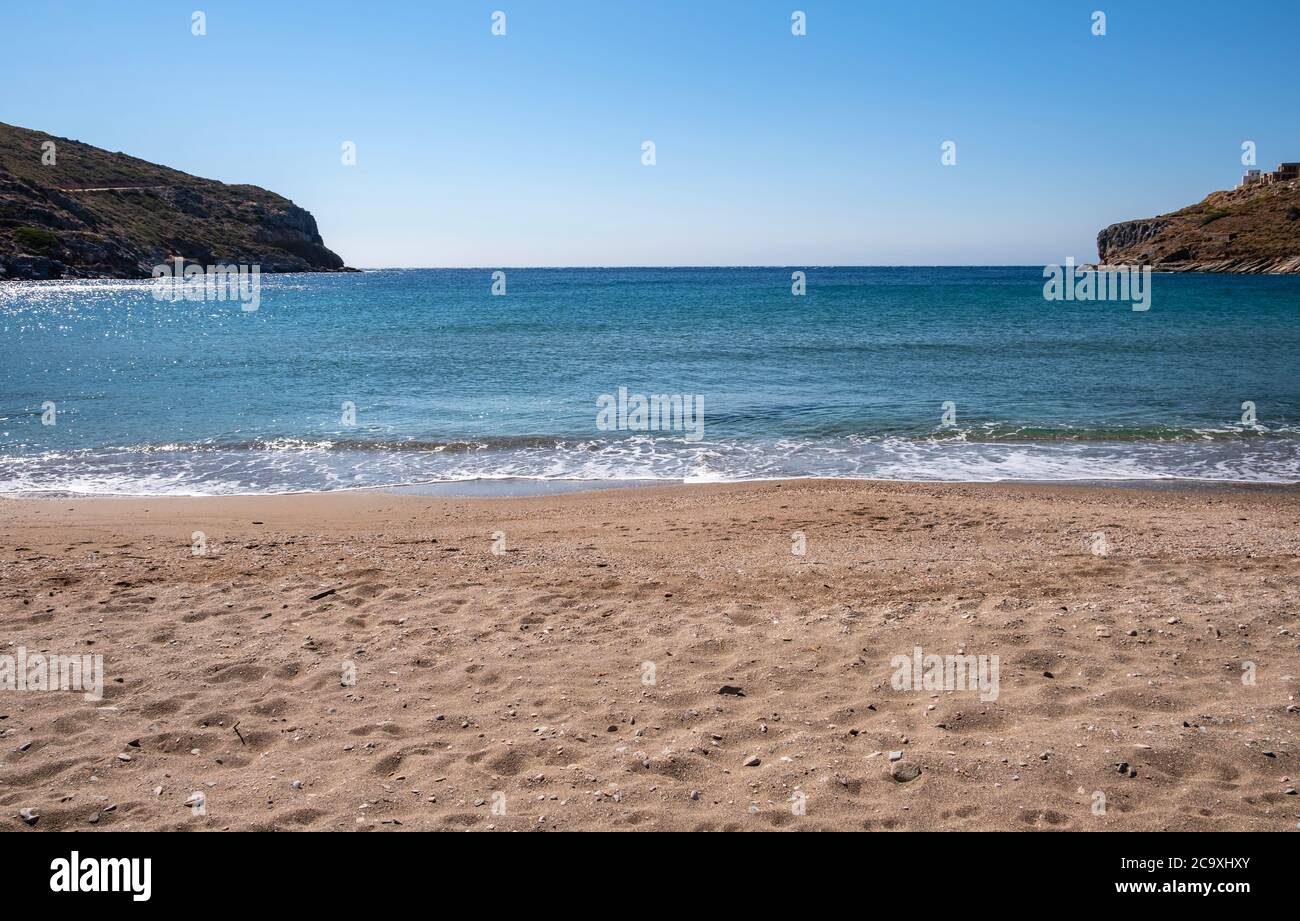 Spiaggia di sabbia, cielo blu chiaro, mare calmo sfondo, Grecia. Isola di Kea, spiaggia di Spathi vuota la mattina presto. Foto Stock