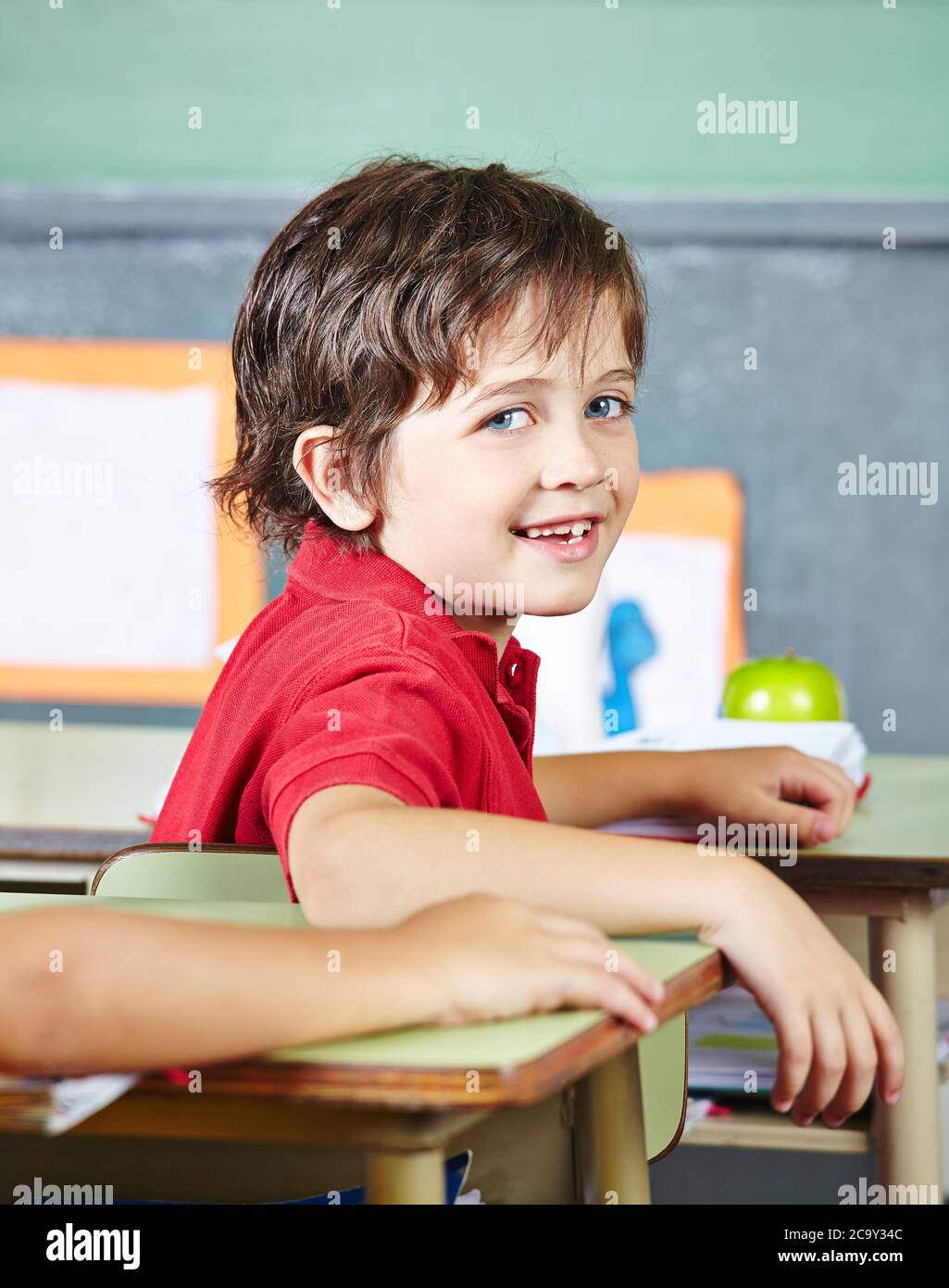 Il bambino felice ride nella scuola primaria in classe Foto Stock
