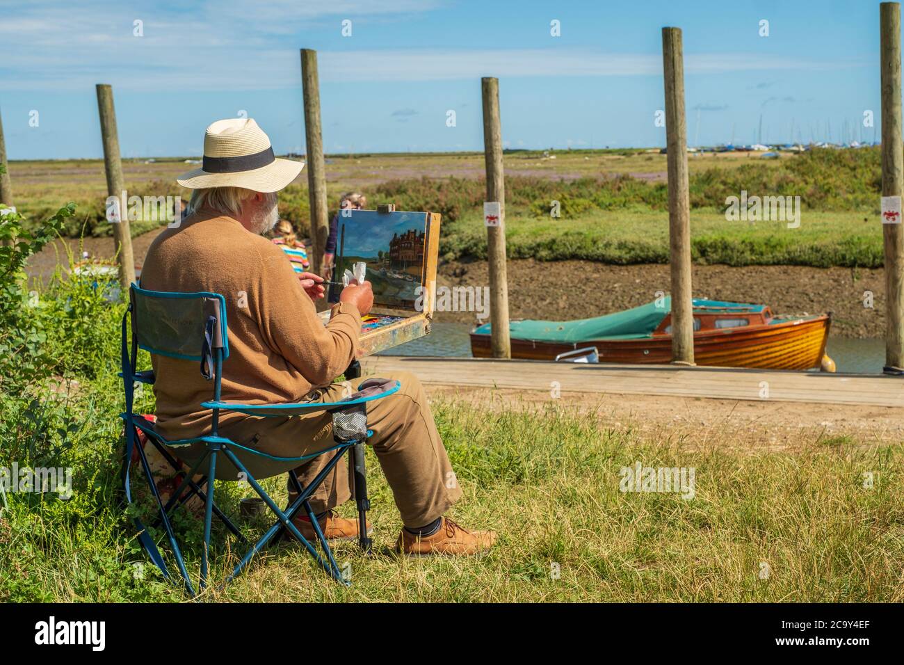 Un artista pittura en plein air sulla costa del Norfolk. Foto Stock