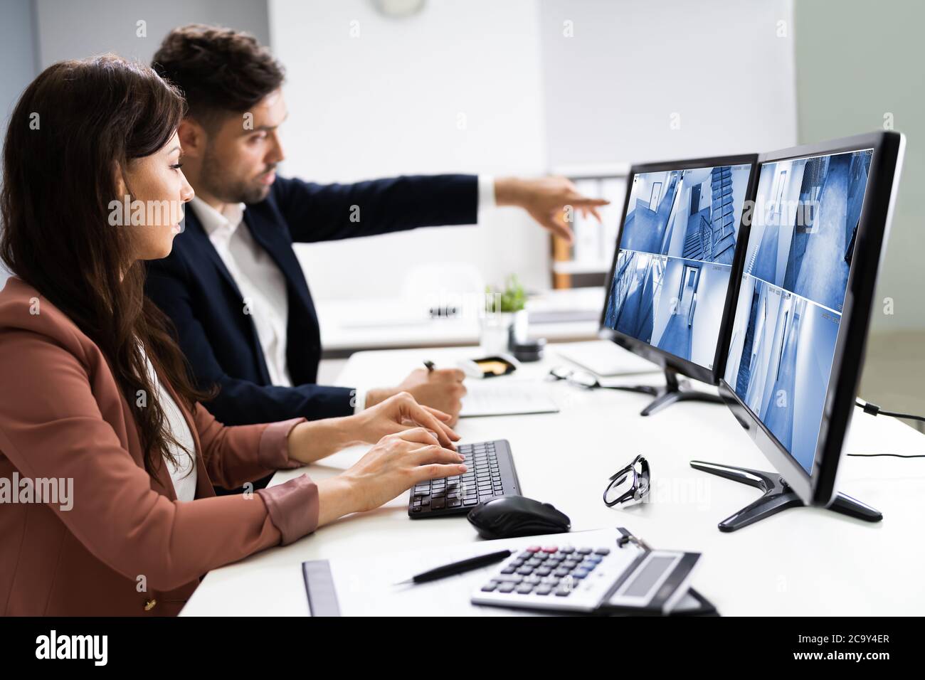 Riprese TVCC controllo di sicurezza operatori che guardano le riprese di sorveglianza sul computer Foto Stock