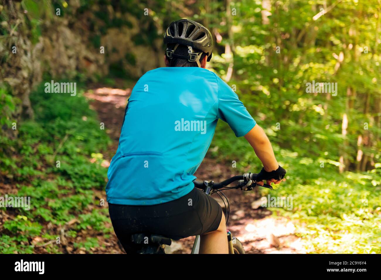 vista posteriore di un ciclista irriconoscibile che cavalca la sua mountain bike, concetto di sport e stile di vita sano in natura Foto Stock