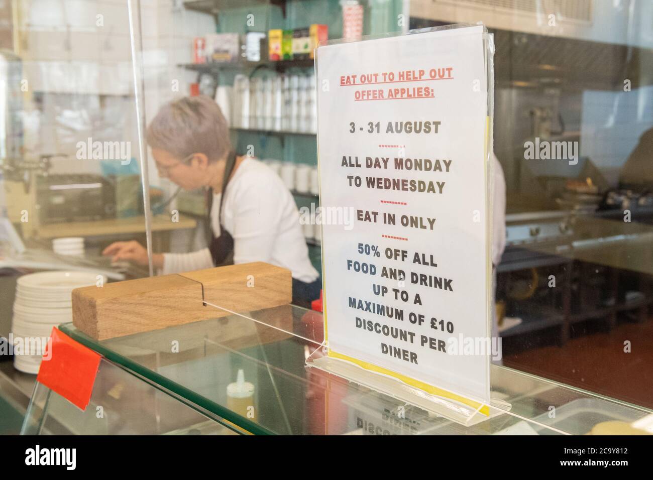 Segnaletica per il programma "Eat out to Help out", presso il Regency Cafe, a Londra, uno dei ristoranti partecipanti dove i clienti potranno gustare pasti a metà prezzo, a partire dal lunedì, quando il governo inizia il suo programma di agosto, volto a incrementare il commercio di ristoranti e pub dopo il blocco. Foto Stock