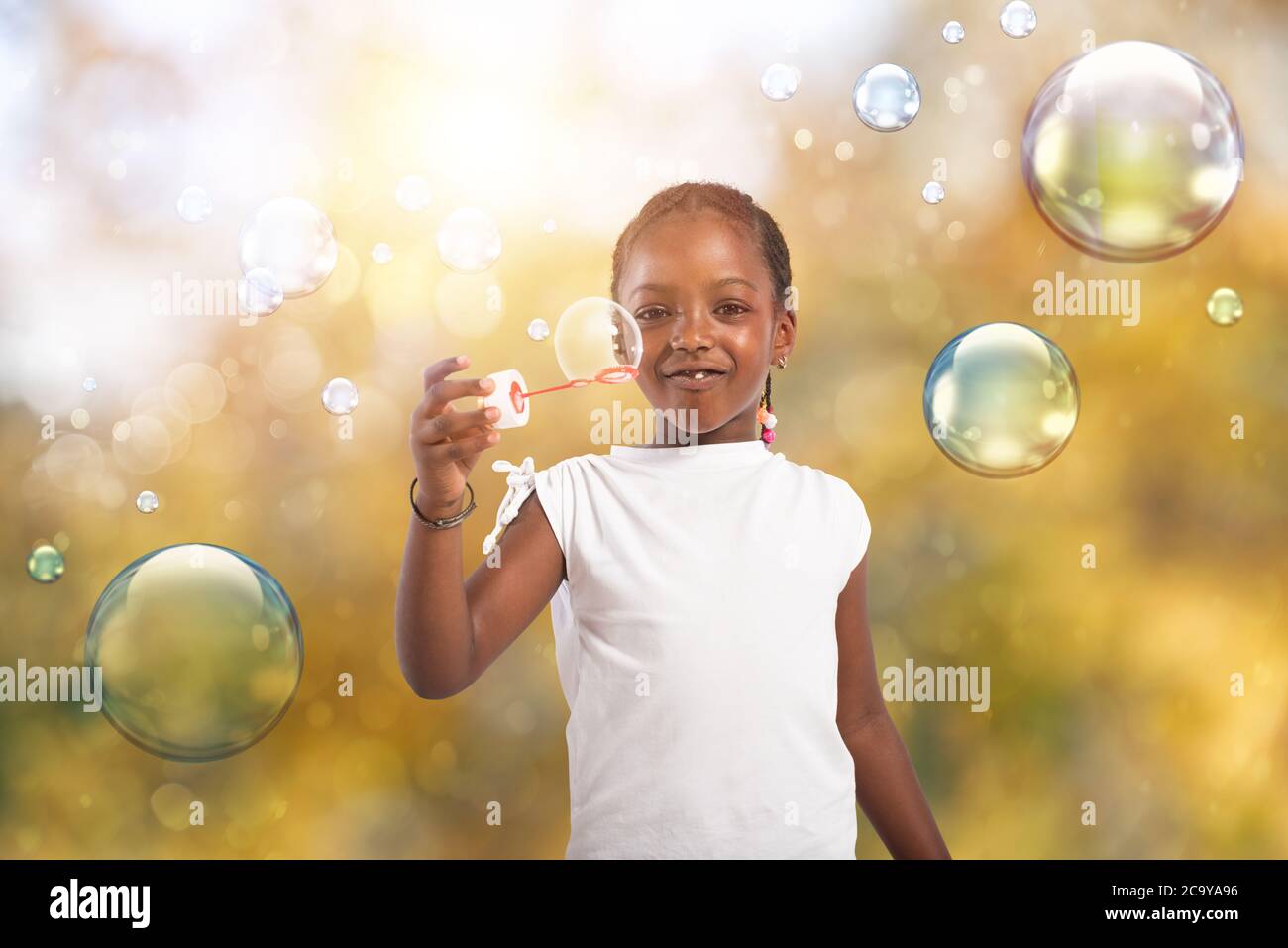 Afro gioco bambino con bolla di sapone all'aperto con una giornata di sole Foto Stock