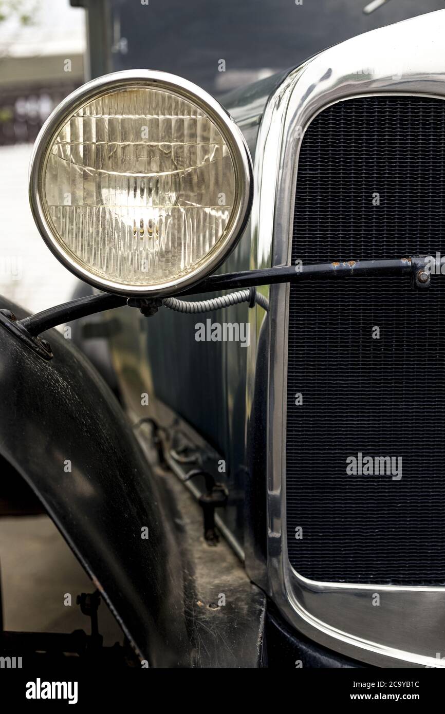 Primo piano verticale del faro rotondo di un vecchio auto Foto stock - Alamy