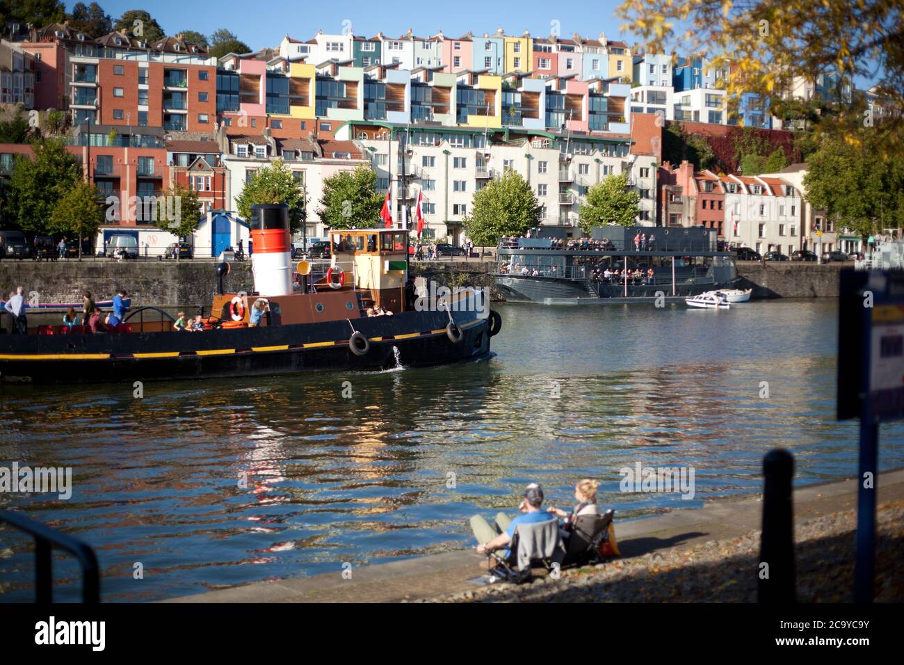 I visitatori di Harbourside guardano un passo in barca a Hotwells, Bristol, Regno Unito Foto Stock