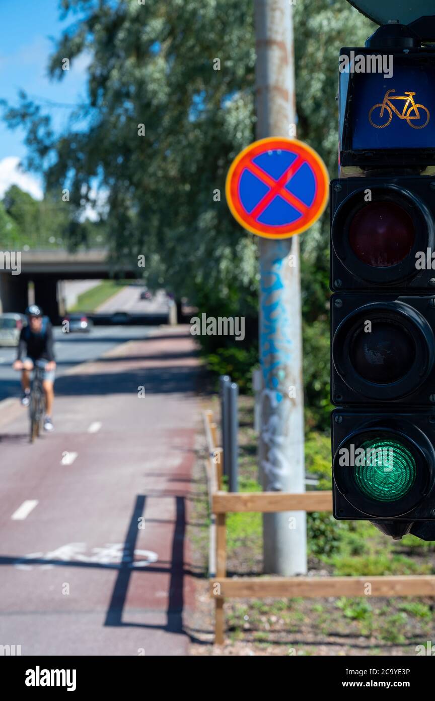 Helsinki / Finlandia - 30 luglio 2020: Un viale per biciclette 'Baana' collega diversi quartieri della città ed è dotato di un proprio semaforo per i motociclisti Foto Stock