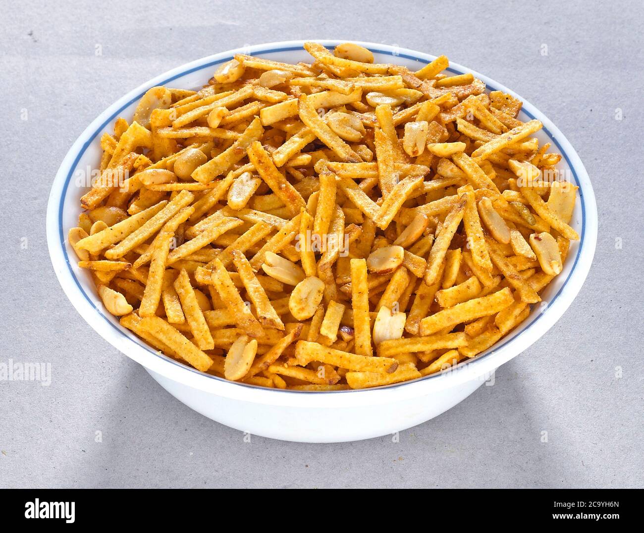 Fritto e piccante dolce Farali chevdo, chivda, Chewada è uno spuntino molto popolare Gujarati, ciotola bianca su sfondo bianco, sacchetto che impacchettano strada comune sna Foto Stock