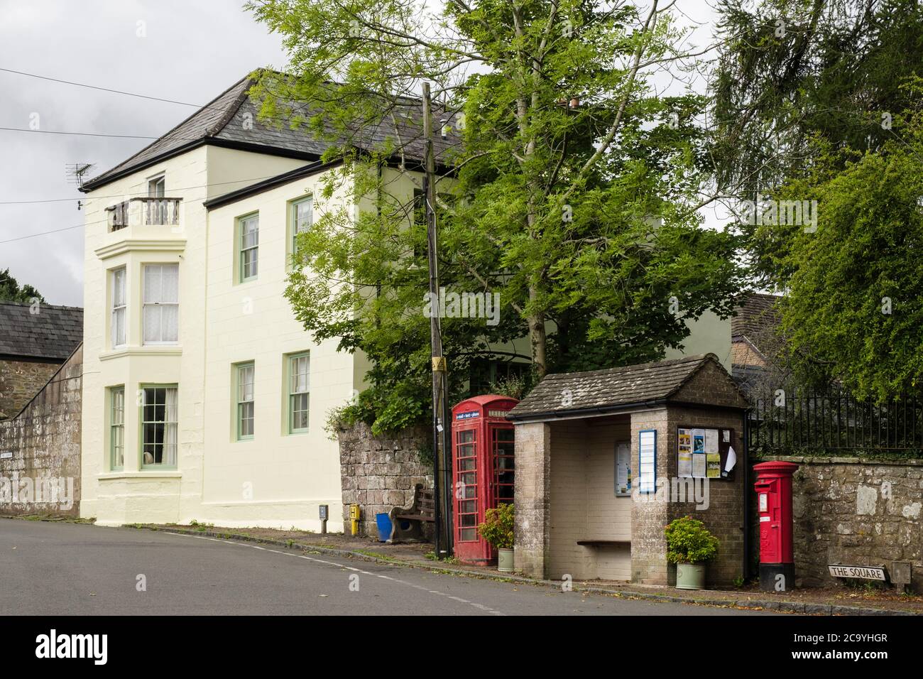 Tradizionale telefono rosso box da bus rifugio e postbox nel centro del villaggio. The Square, St Briavel's, Forest of Dean Gloucestershire, Inghilterra, Regno Unito Foto Stock