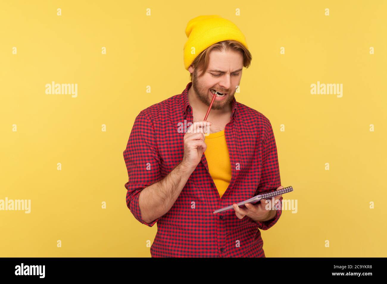 Uomo pensivo in cappello hipster beanie in piedi matita mordente  pensieroso, meditando idea di scrivere nel notebook, prendendo appunti in  carta, pensando al busin Foto stock - Alamy