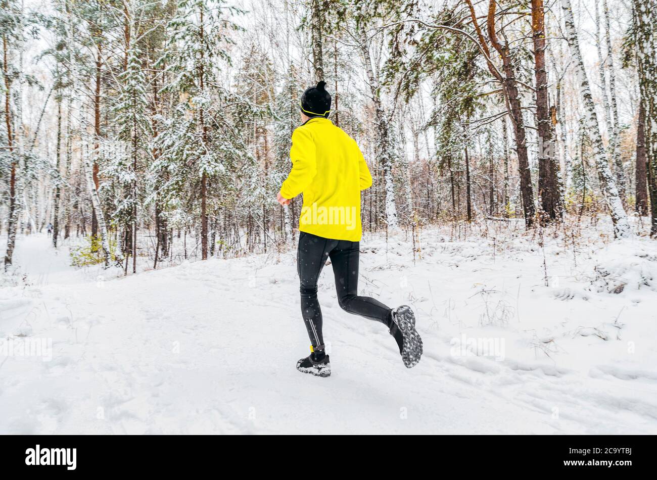 atleta uomo corridore in giubbotto corrono inverno foresta pista Foto Stock