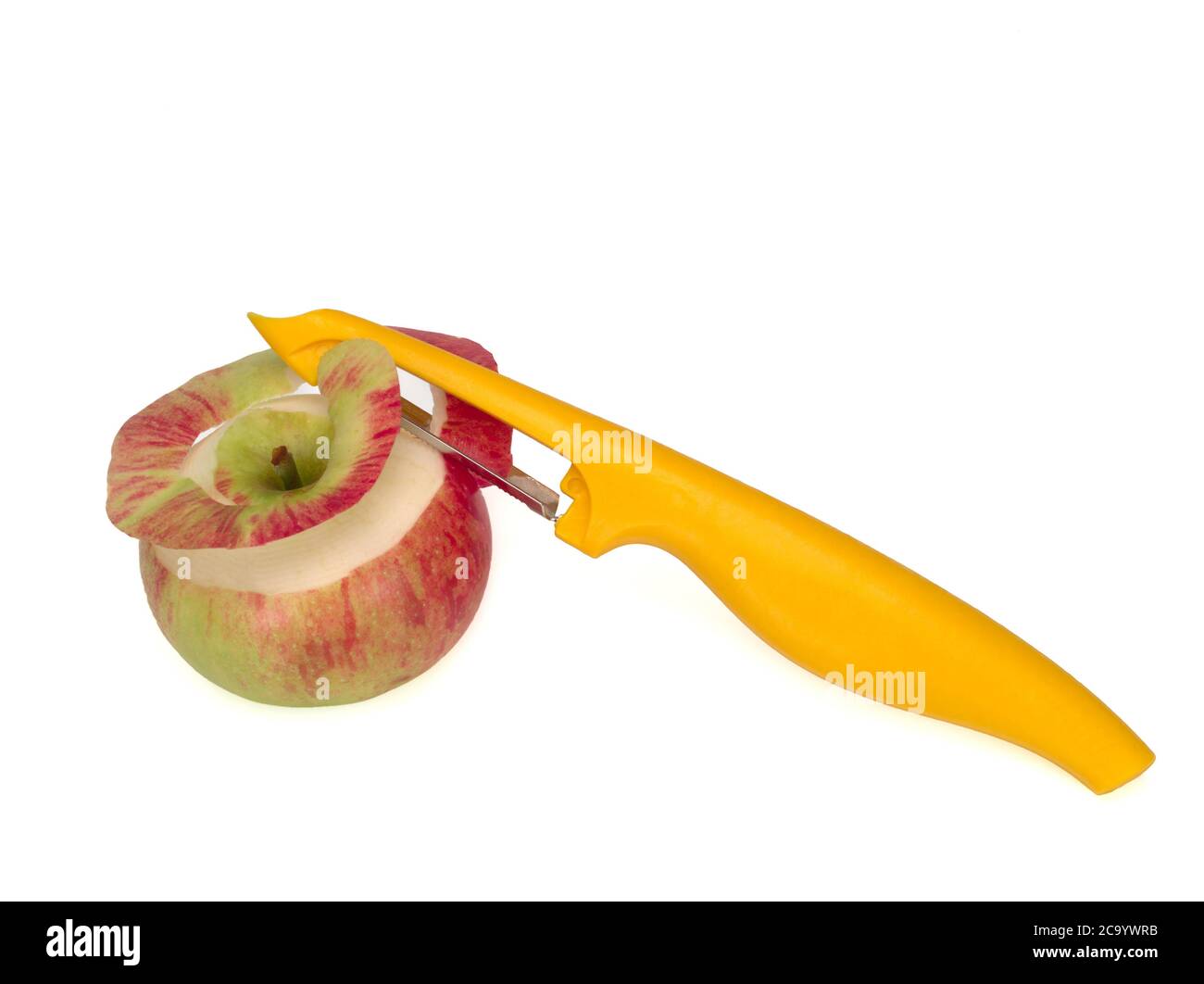 Pelatore giallo, utilizzato per sbucciare una mela su sfondo bianco. Coltello, pelatore per verdure e frutta Foto Stock