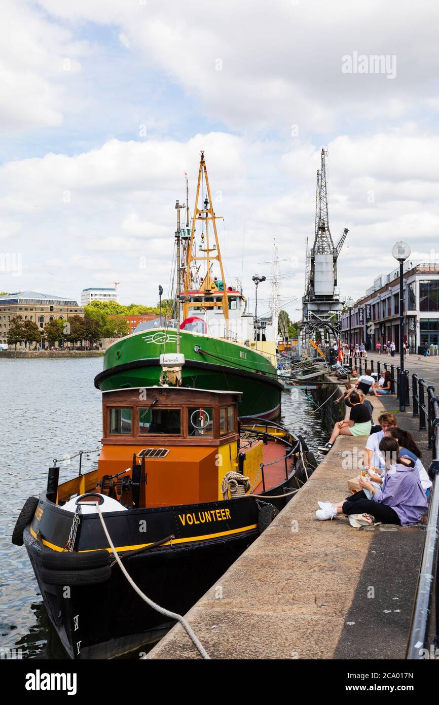 Si può prendere il sole sulla banchina con le barche "Volontario" ormeggiate a Princes Wharf, Bristol, Inghilterra. Luglio 2020 Foto Stock