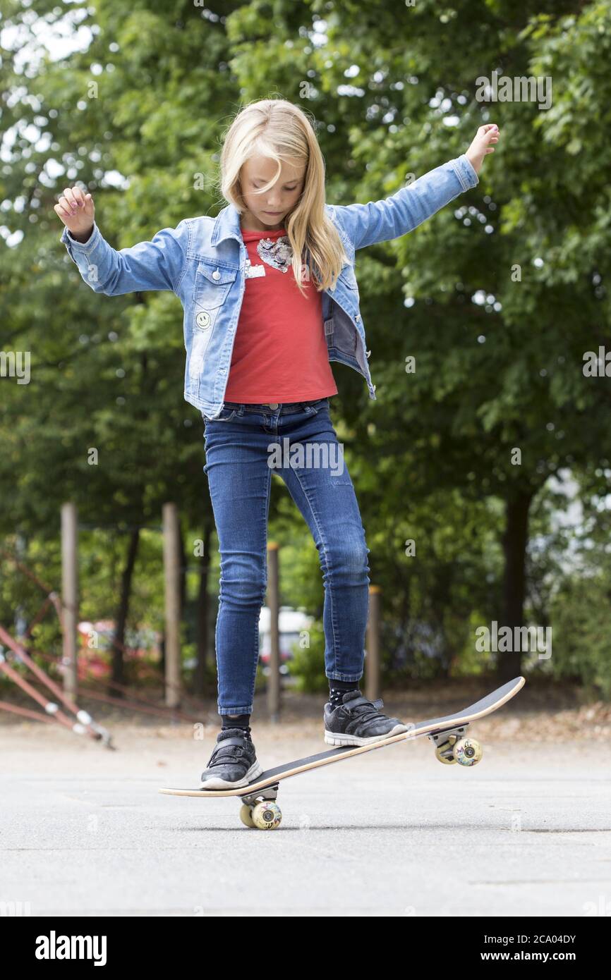 Girl (10) si trova su skateboard inclinabile, Kiel, Schleswig-Holstein, Germania Foto Stock