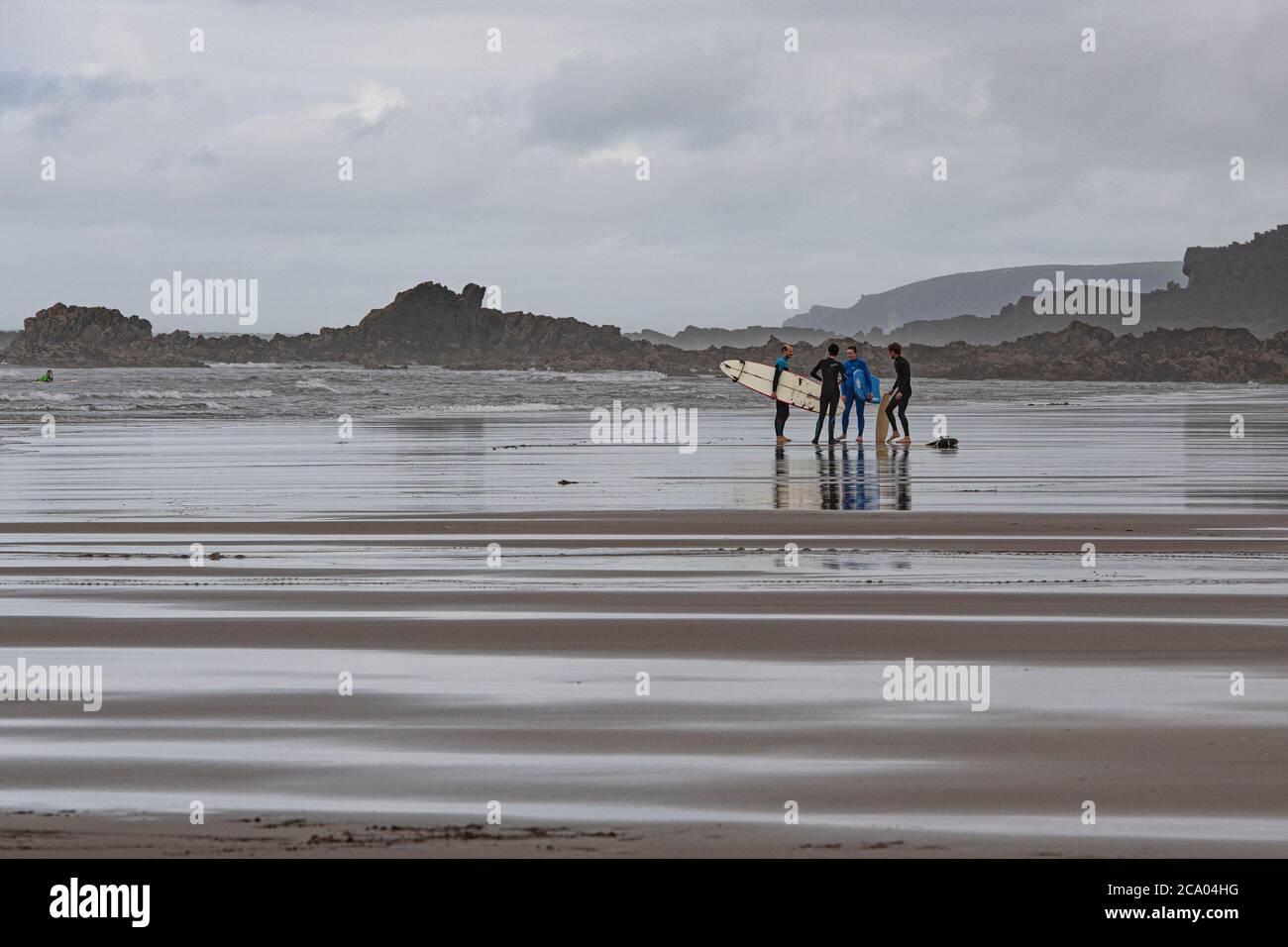 surfers su una spiaggia della cornovaglia Foto Stock