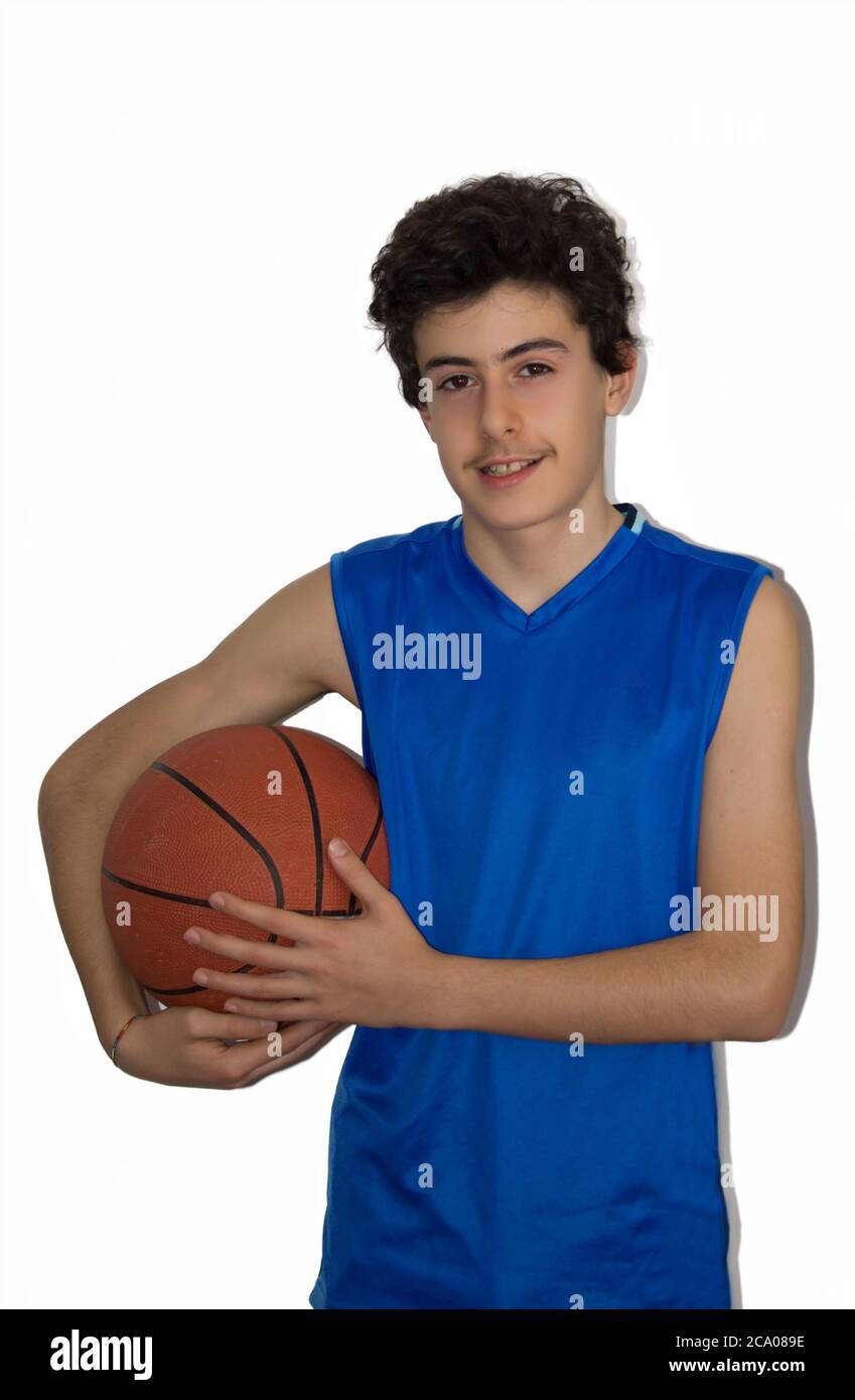 Ragazzo giovane che gioca a basket in uno sfondo isolato Foto