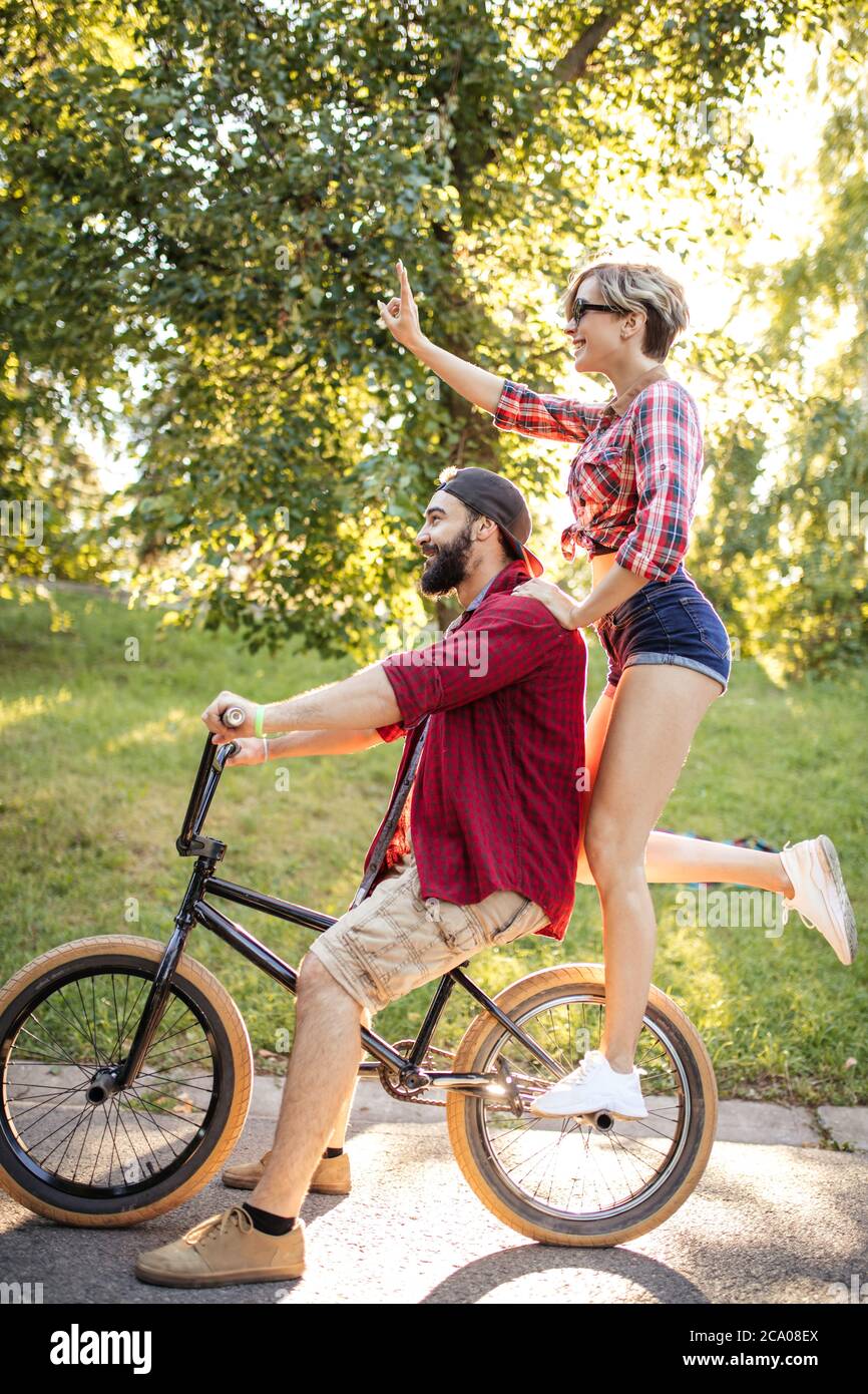 Felice giovane coppia che va per un giro in bicicletta in una giornata  estiva di sole