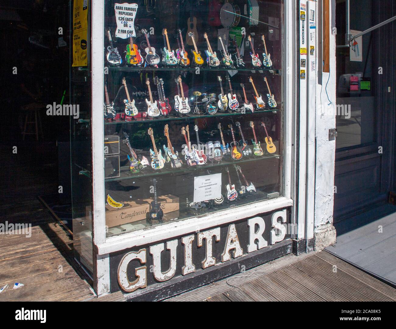 Chitarre in miniatura in vetrina di un negozio di chitarra, Camden, Londra, Regno Unito Foto Stock
