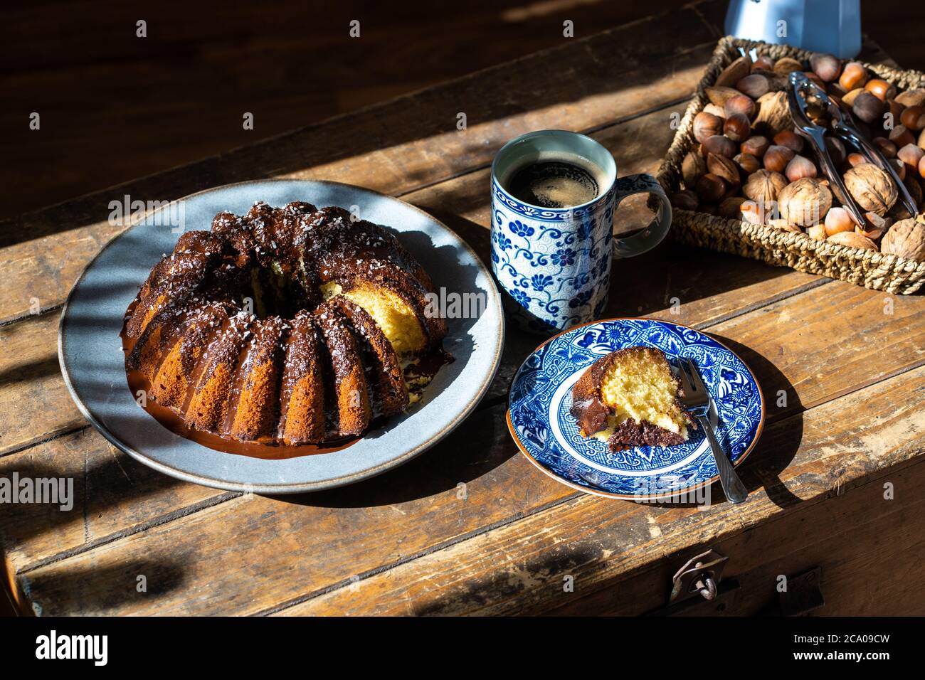 Deliziosa torta di Pasqua, cestino di noci e cacao caldo su vecchio tavolo di legno scuro - perfetto mattina facile durante il soggiorno a casa. Foto Stock