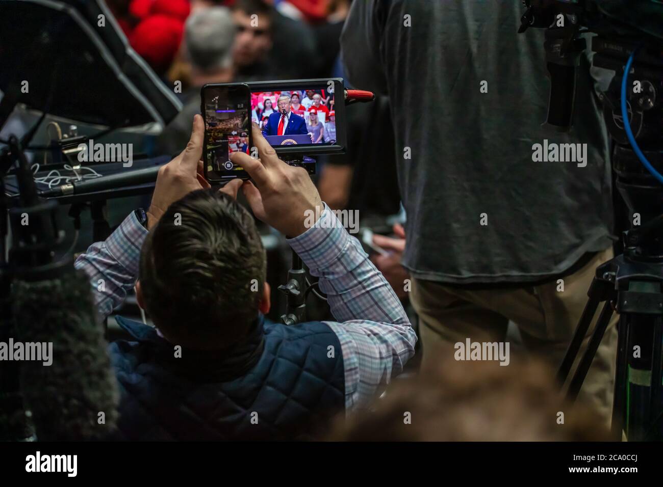 Membro del pool stampa prende cellulare foto del presidente Discorso di Trump al rally nel Bojangle's Coliseum Foto Stock