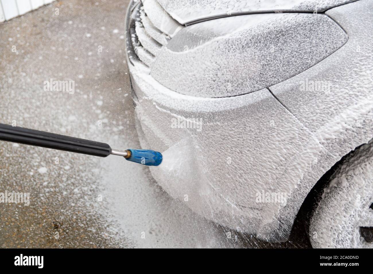 Una vista in primo piano del processo di lavaggio interno di auto bagnate. Lato anteriore con faro. Foto Stock