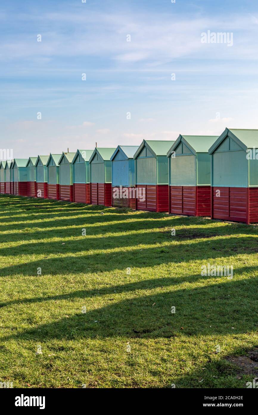 Lunghe ombre di capanne sulla spiaggia in un giorno di inverni soliti Foto Stock