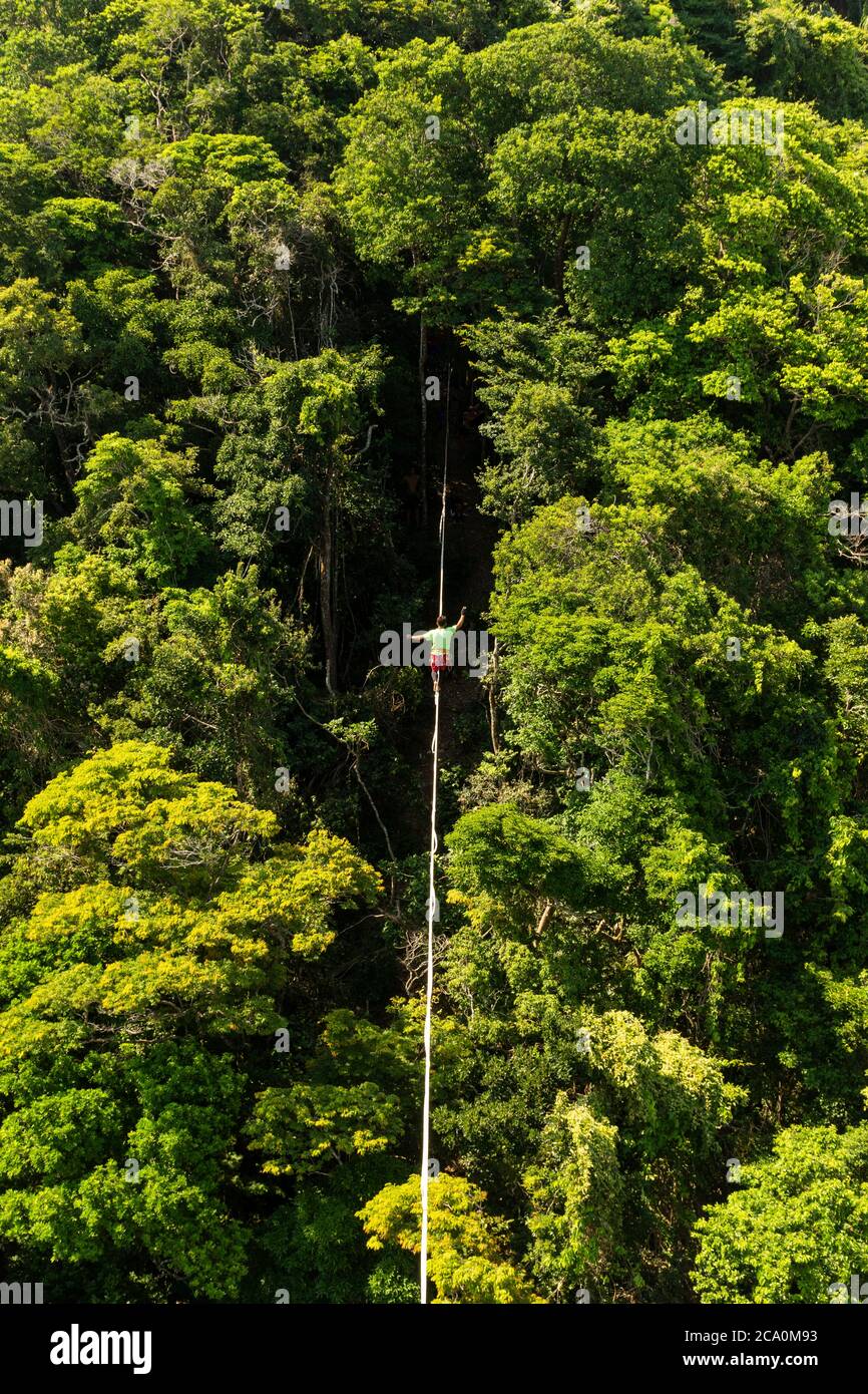 Bellissimo paesaggio di uomo slacklining sulla foresta pluviale a Rio de Janeiro, Brasile Foto Stock