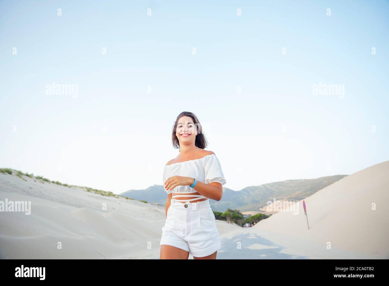 Giovane donna che cammina lungo le dune Foto Stock