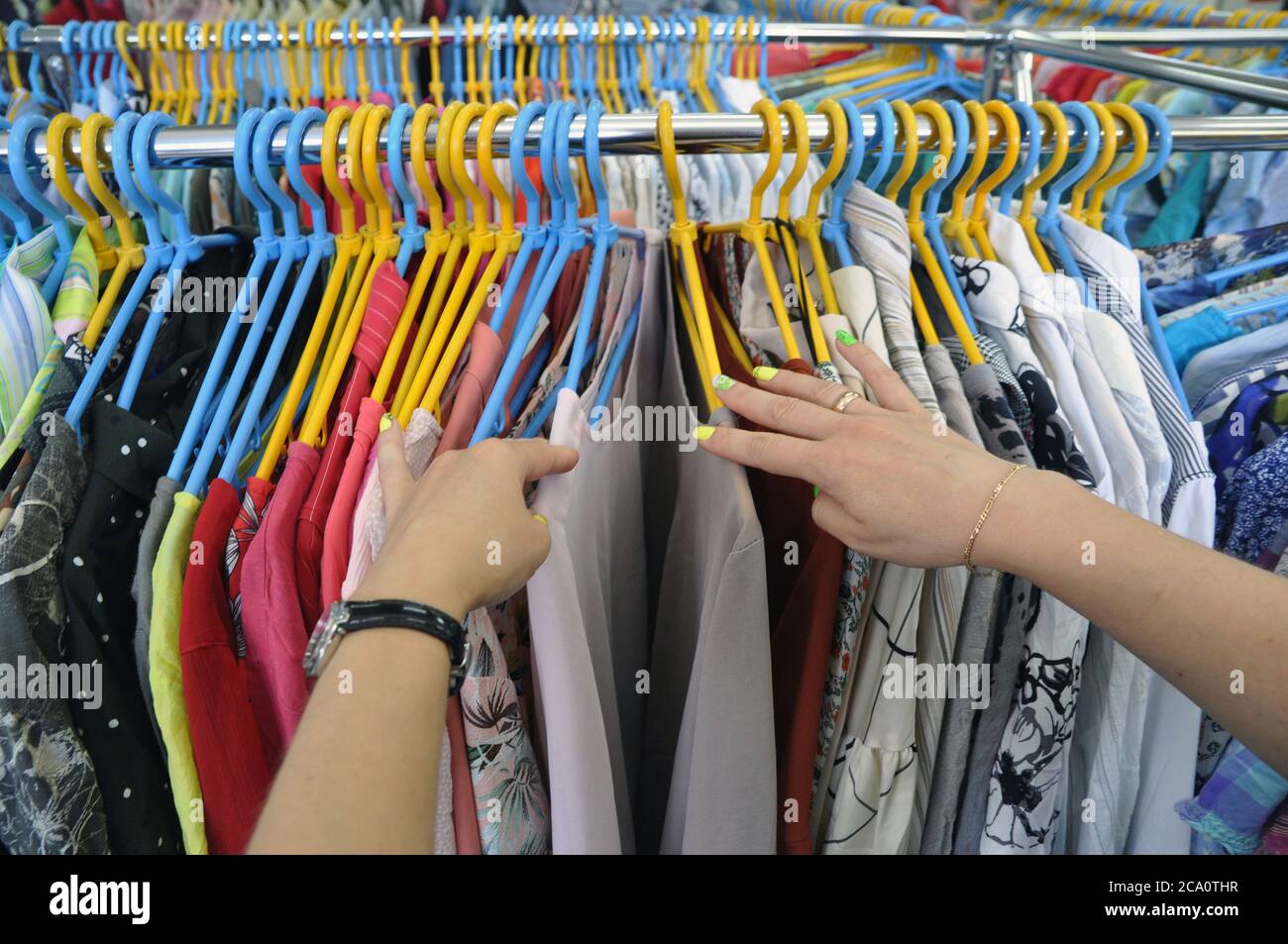 L'acquirente seleziona i vestiti in un negozio di seconda mano. Foto Stock