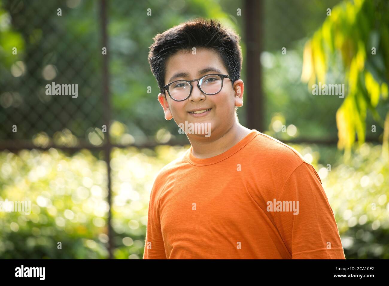 Felice ragazzo a parco guardando la macchina fotografica Foto Stock