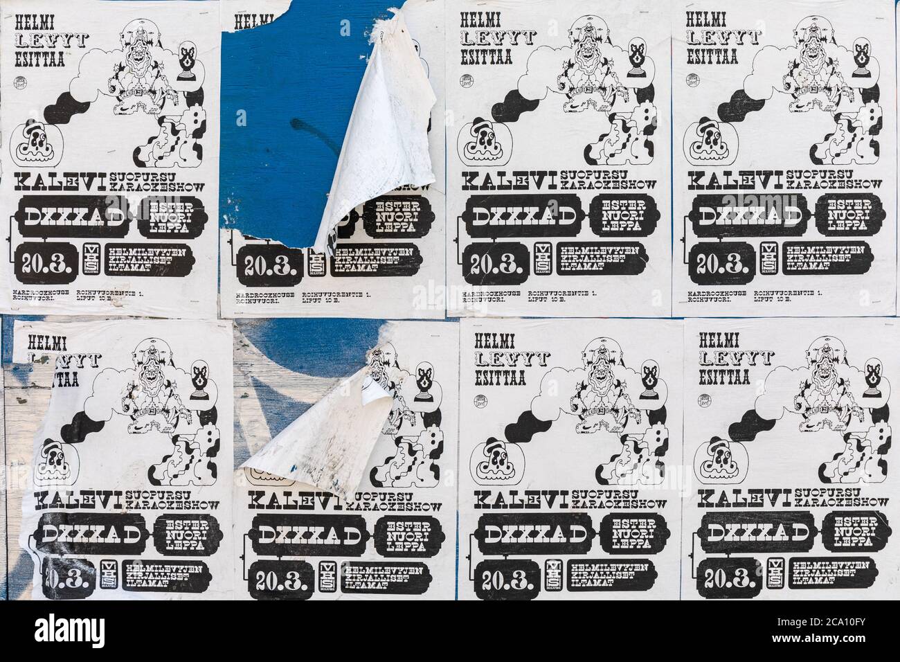 Poster lacerati su parete in compensato blu nel quartiere Suvilahti di Helsinki, Finlandia Foto Stock