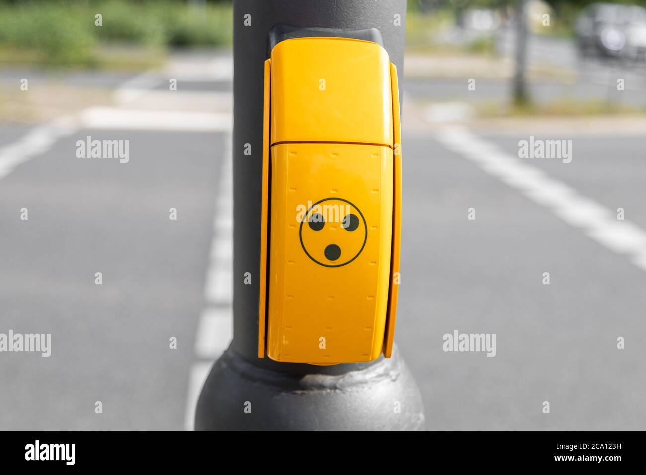 pulsante giallo per persone non vedenti, disabili o disabili al semaforo per ricevere un segnale acustico quando il semaforo è verde per attraversare la strada Foto Stock