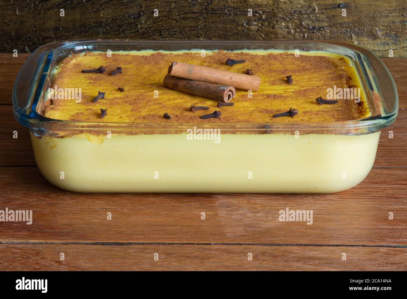 Canjica. Curau. Dolci tipici brasiliani per la festa della junina. Rustico legno di fondo. Dessert brasiliano Foto Stock