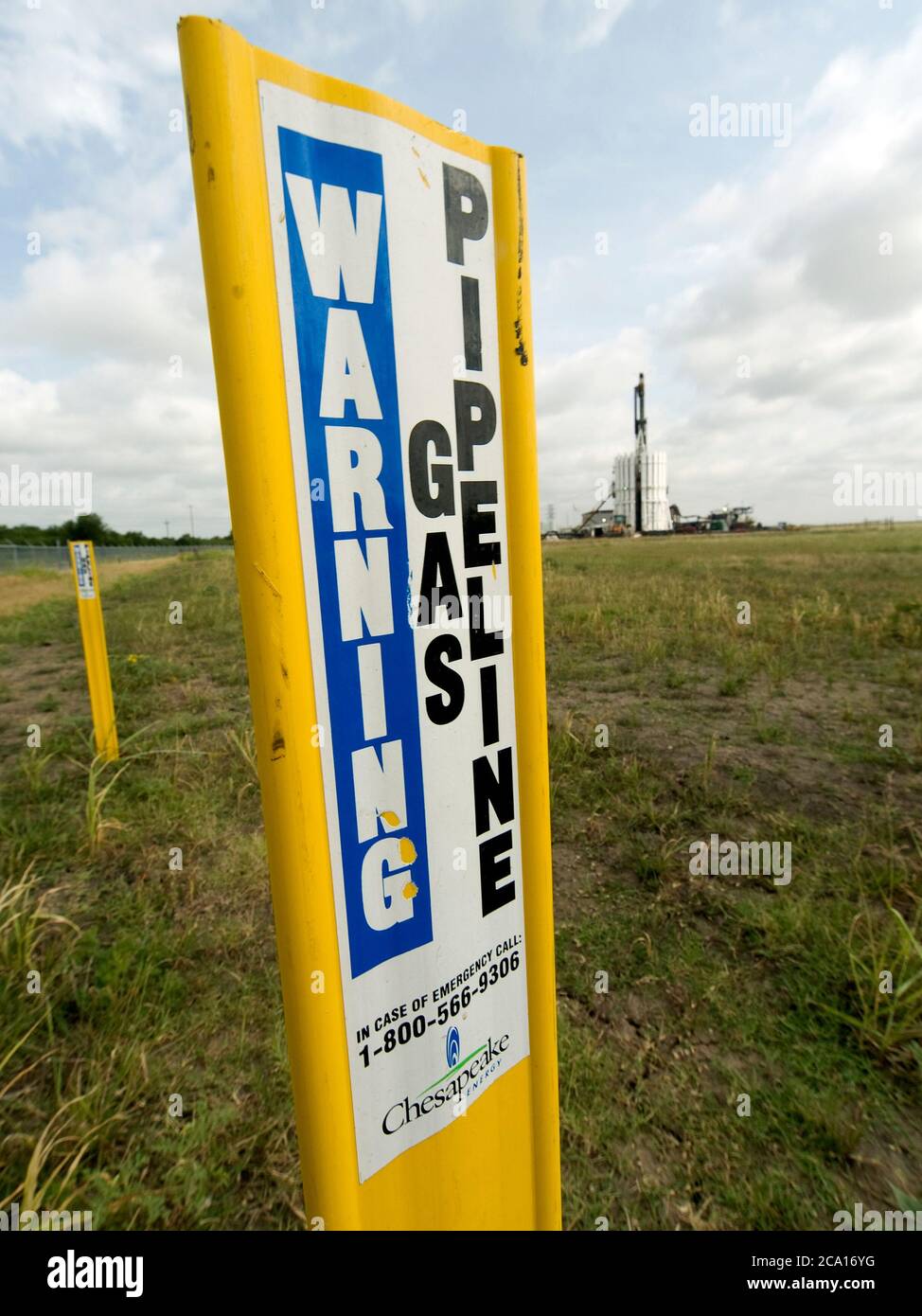 Tubi in attesa di essere aggiunti ad una conduttura che collega un sito di perforazione con una rete di condotte che portano il gas naturale alle centrali elettriche. La conduttura passa sotto linee elettriche prodotte dal gas naturale. Foto Stock