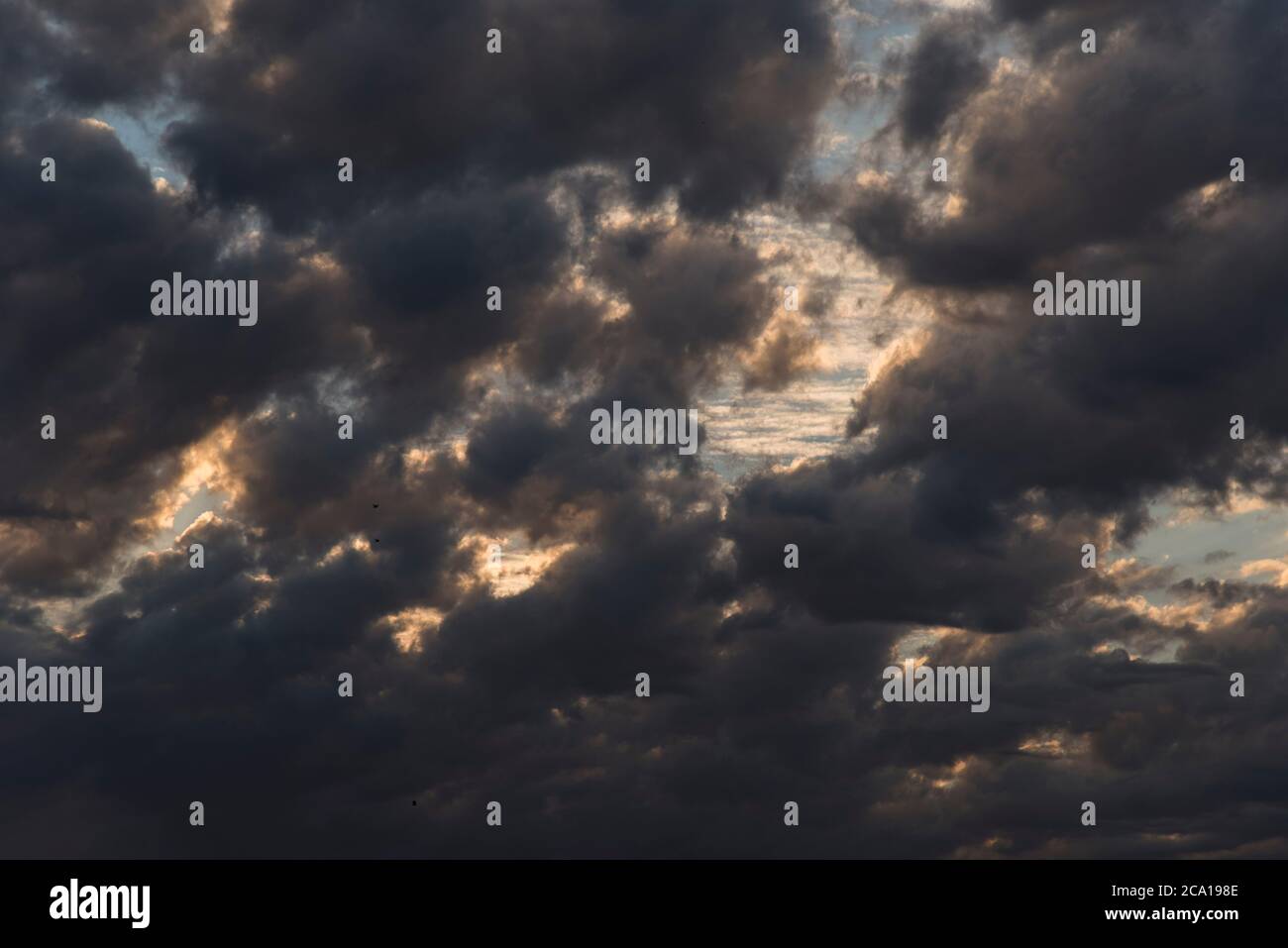 Nuvoloso, cielo pieno di nuvole grigio scuro al tramonto Foto Stock