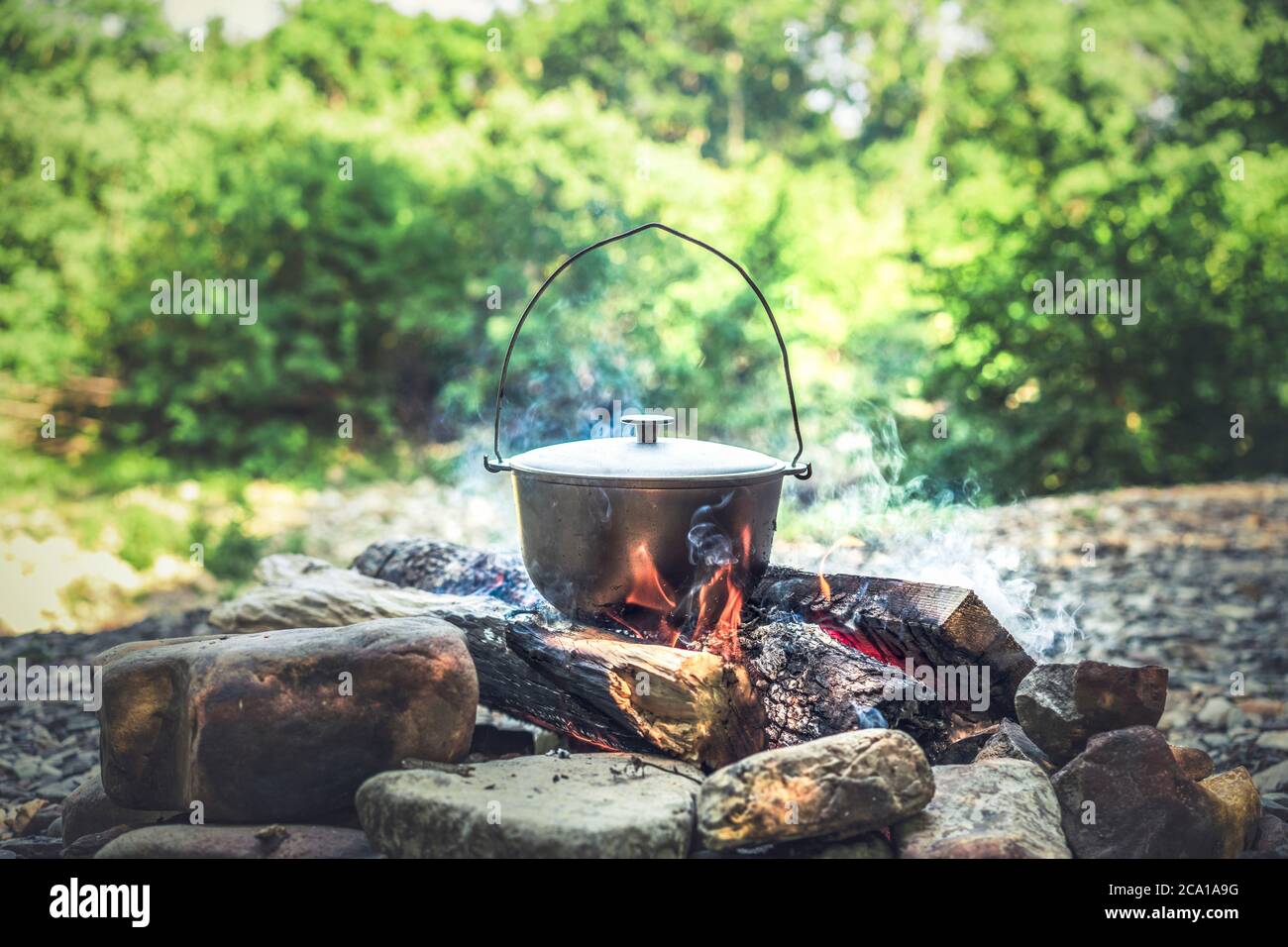 Viaggi, turismo, cucina pic-nic, cucinare in un calderone sul fuoco, bollente pentola al fuoco sul pic-nic. Foto Stock