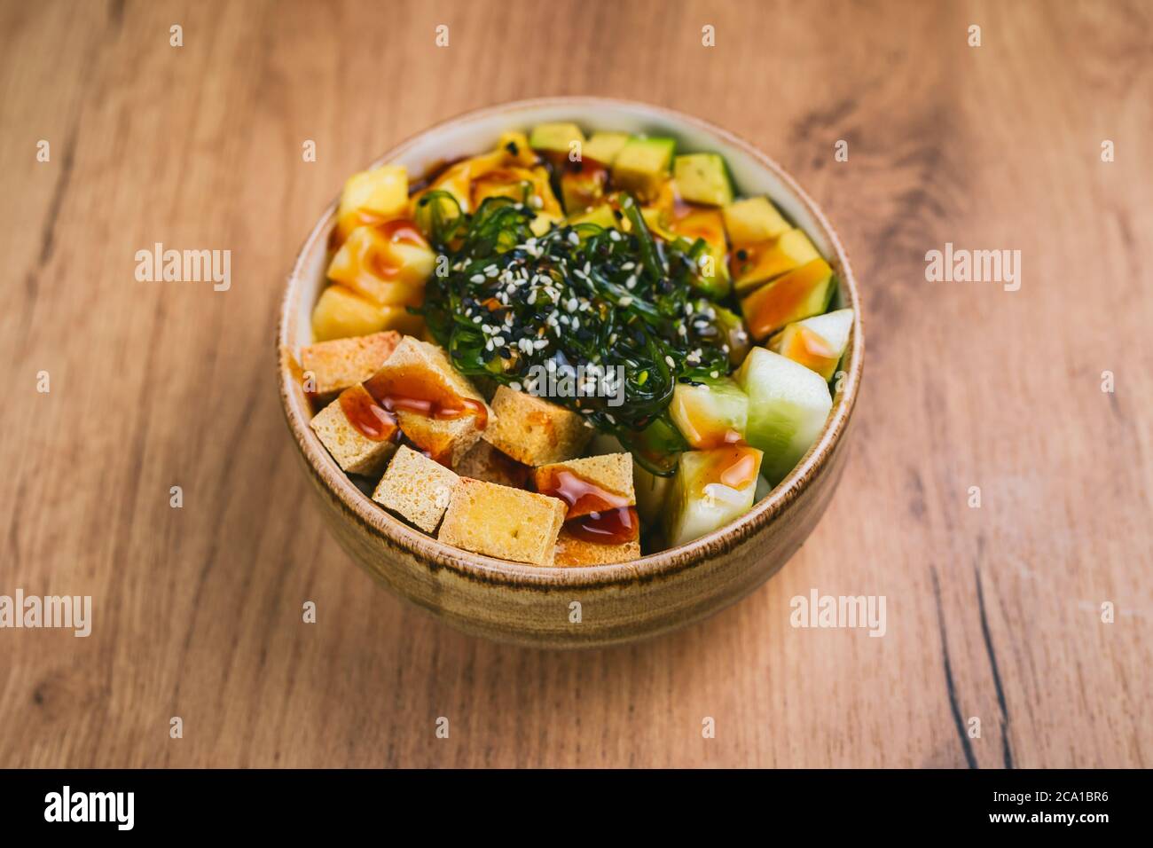 Ciotola con tofu, cetriolo, avokado, mango e insalata di chuka Foto Stock
